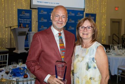 Man holding award next to a women